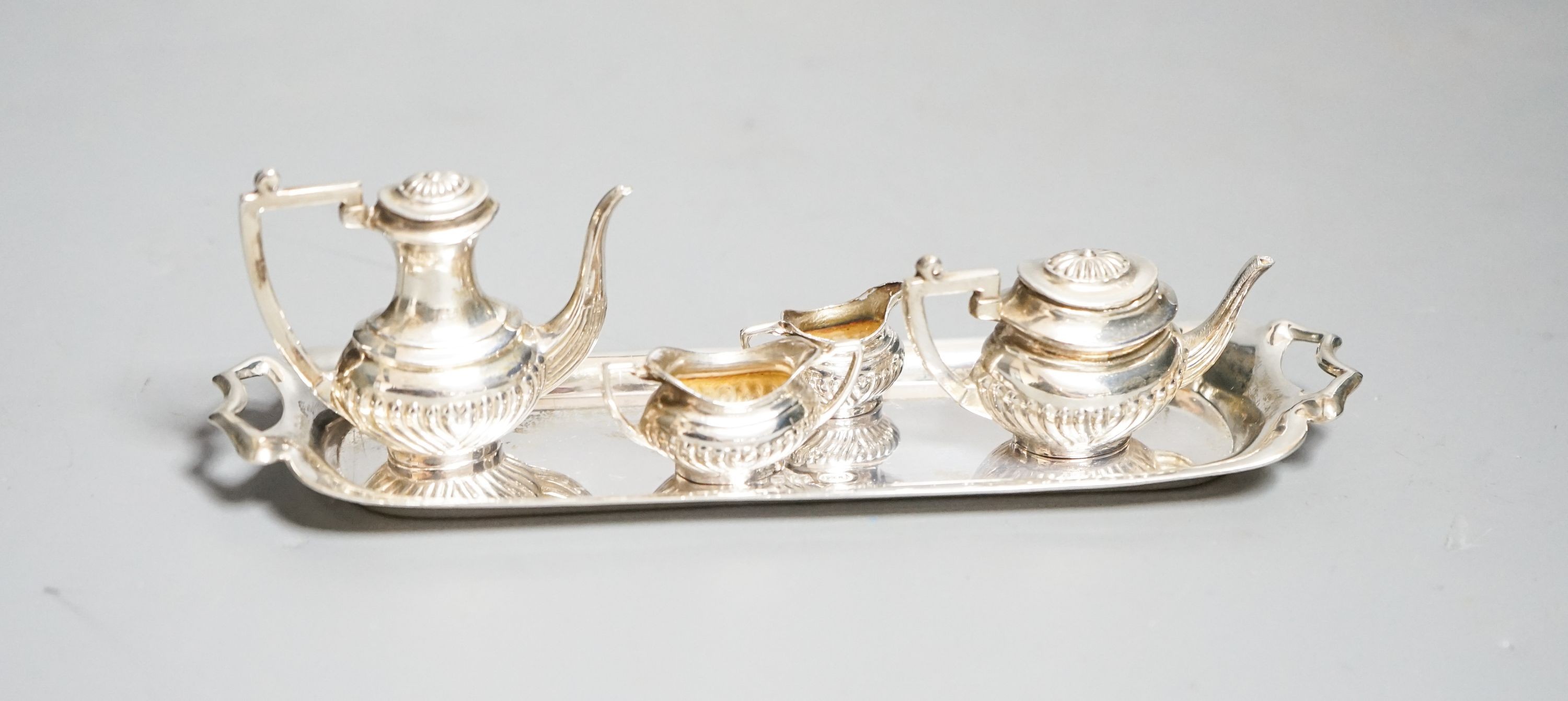 A modern silver miniature four piece tea set and two handle tea tray, London, 1979, tray 14.8cm.